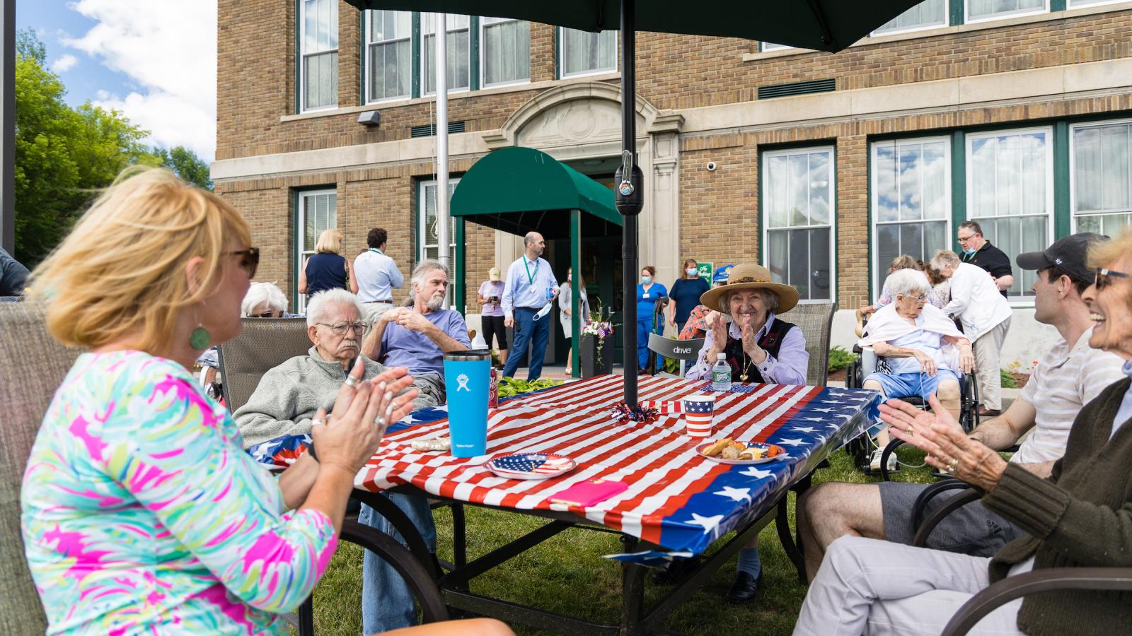 Residents talking while enjoying an outdoor BBQ event.