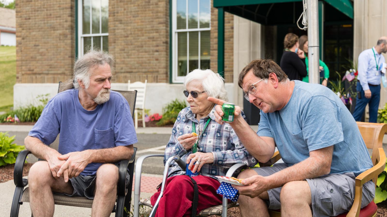 A resident visiting with family, outside during a community event.