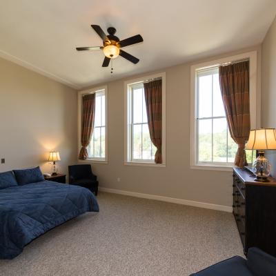 Spacious assisted living bedroom room with ceiling fan at Champlain Valley Senior Living
