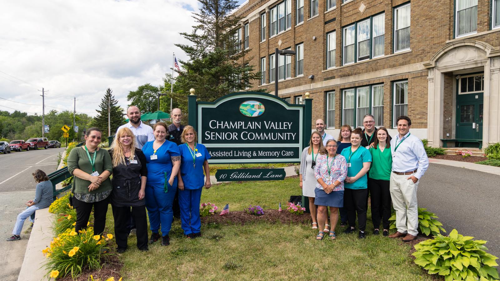 Staff gathered around CVSC entrance sign. 