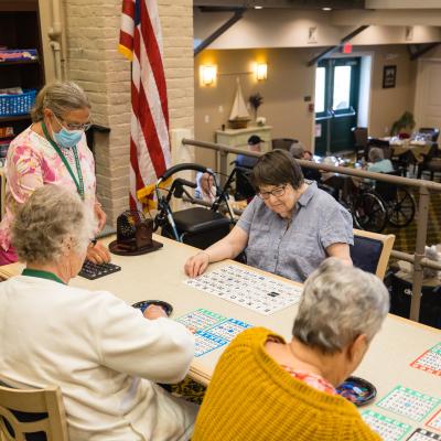 Residents gathered around gaming table. 