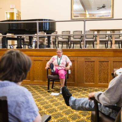 A nurse with residents performing leg exercises.