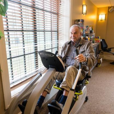 A male resident using an elliptical machine in the facility gym.