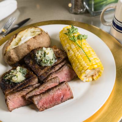 A plated meal of steak and corn.