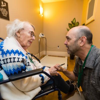 A resident using a wheelchair, receiving an assessment by a resident doctor.