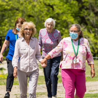 Two nurses and two residents enjoying a walk outside.