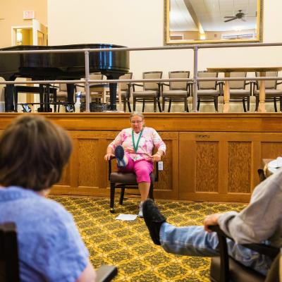 Staff member leading residents thru seated exercises. 