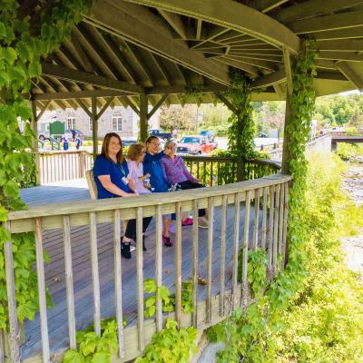 Group of residents and staff seated in outdoor gazebo.